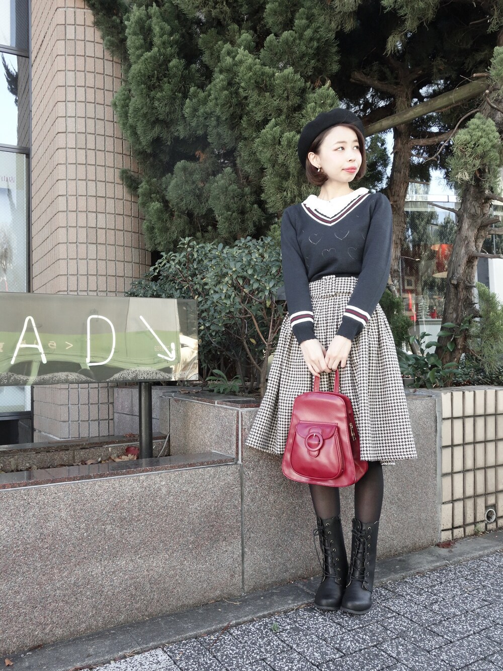 ブルー系のニット/セーター、ブラウン系のスカート、ブラック系のバックパック/リュックを着用したレディースの冬コーディネートの1枚目の写真