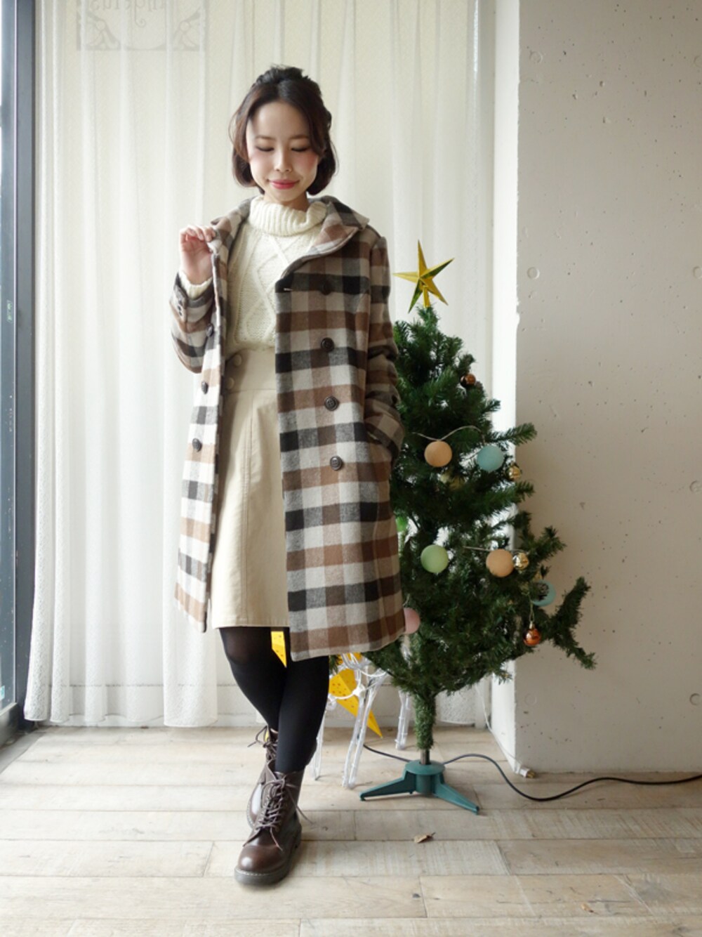 ホワイト系のニット/セーター、ホワイト系のスカート、ブラウン系のカバーオールを着用したレディースの冬コーディネートの1枚目の写真