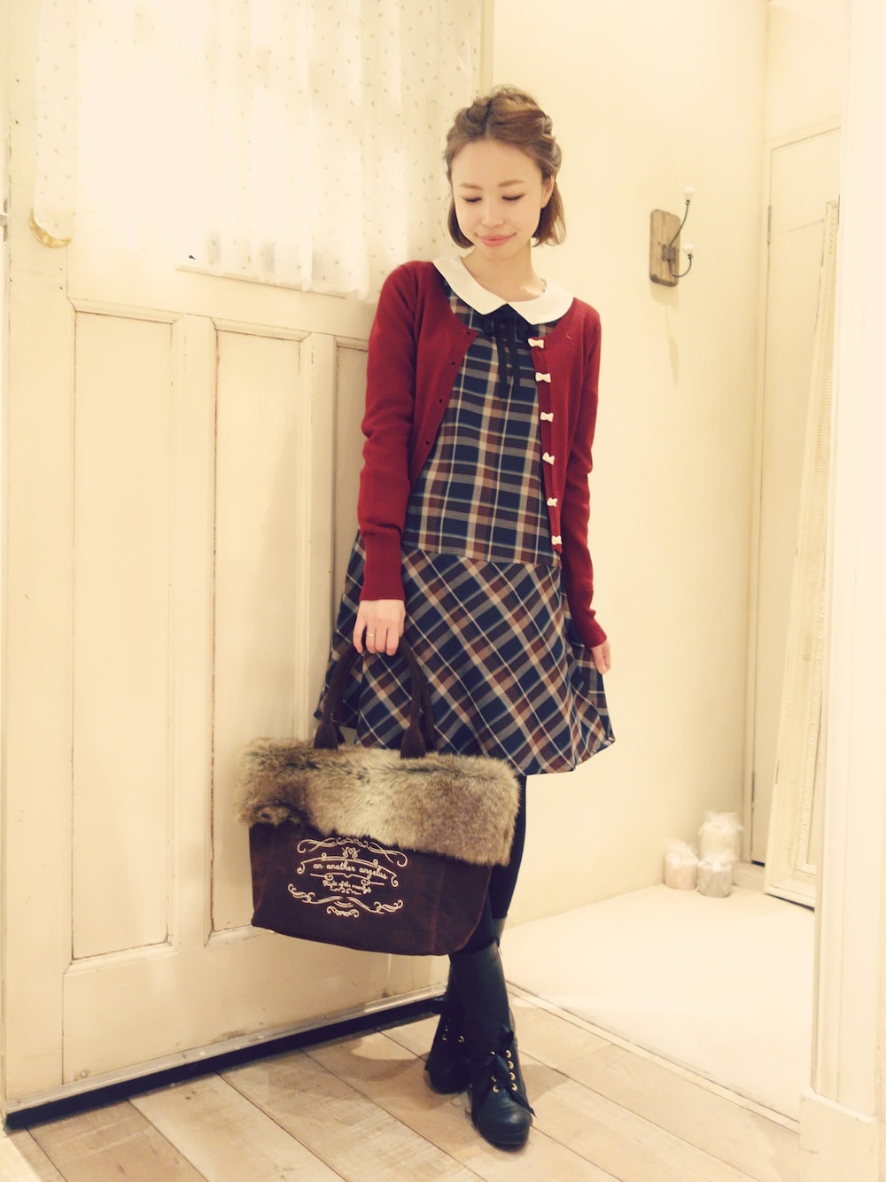 ブラウン系のワンピース、レッド系のカーディガン/ボレロ、ブラウン系のトートバッグを着用したレディースの冬コーディネートの1枚目の写真