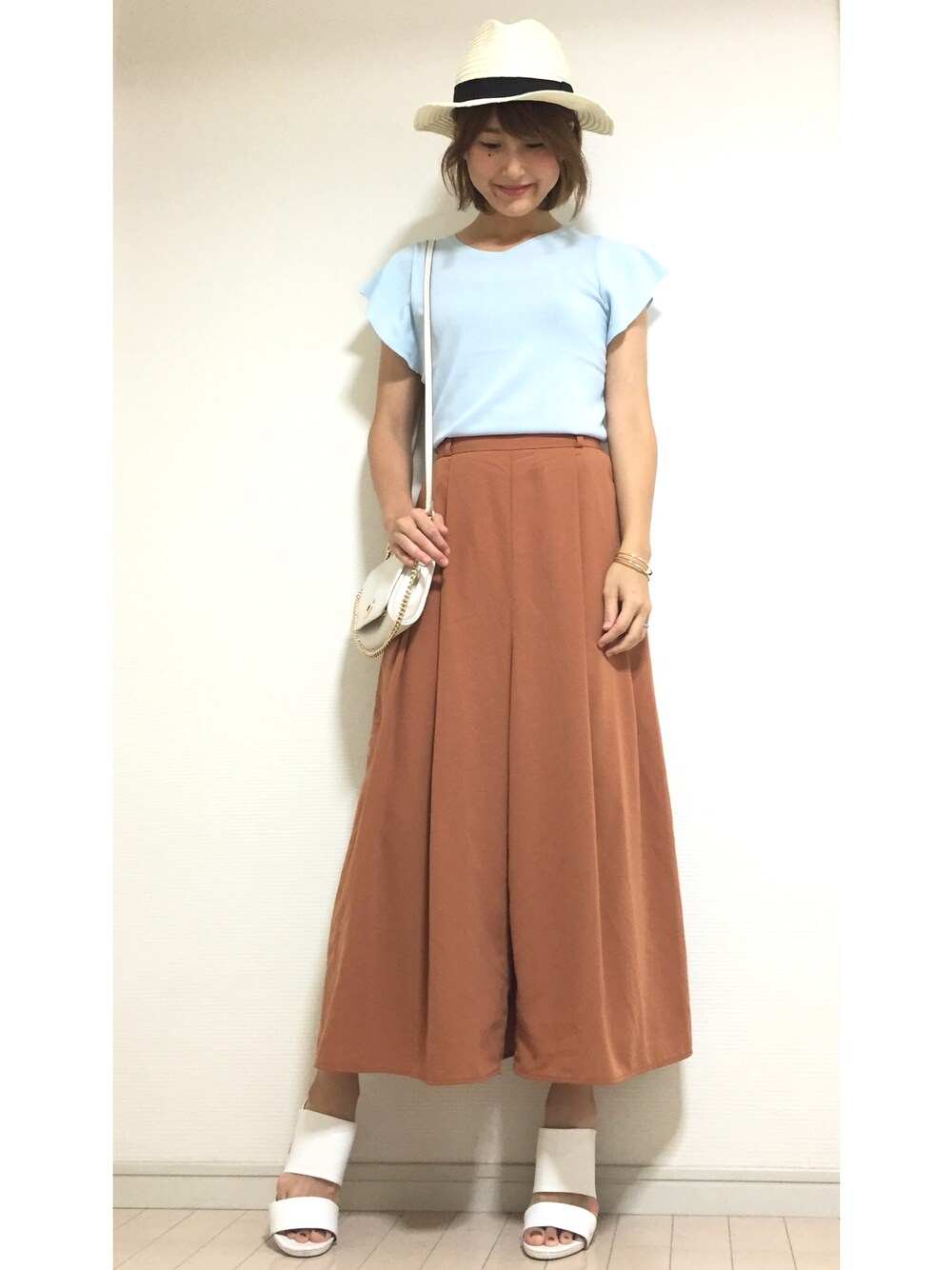 ブルー系のニット/セーター、ホワイト系のショルダーバッグ、ブラウン系のその他パンツを着用したレディースの夏コーディネートの1枚目の写真