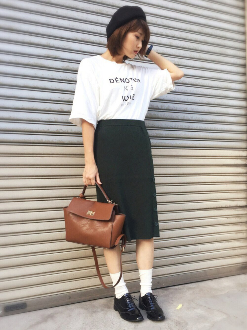 ホワイト系のTシャツ/カットソー、グリーン系のスカート、ブラウン系のハンドバッグを着用したレディースの秋コーディネートの1枚目の写真