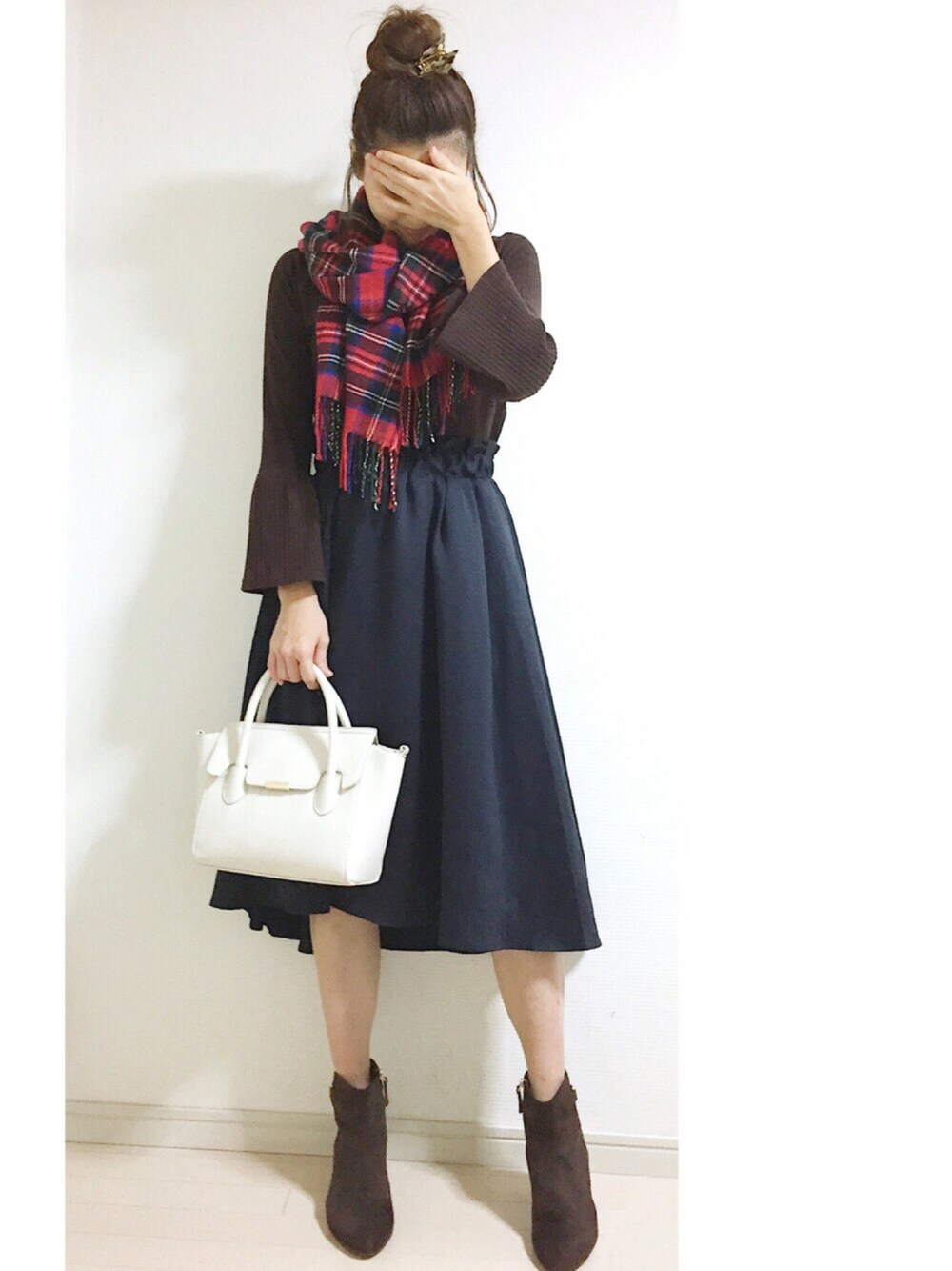 ブラウン系のTシャツ/カットソー、ブルー系のスカート、ホワイト系のボストンバッグを着用したレディースの秋コーディネートの1枚目の写真