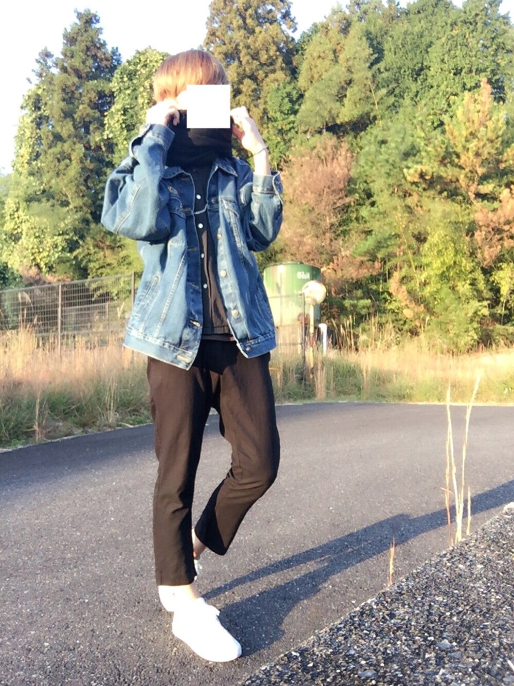 ホワイト系のスニーカー、ブルー系のデニムジャケット、ブラック系のシャツ/ブラウスを着用したメンズの秋コーディネートの1枚目の写真