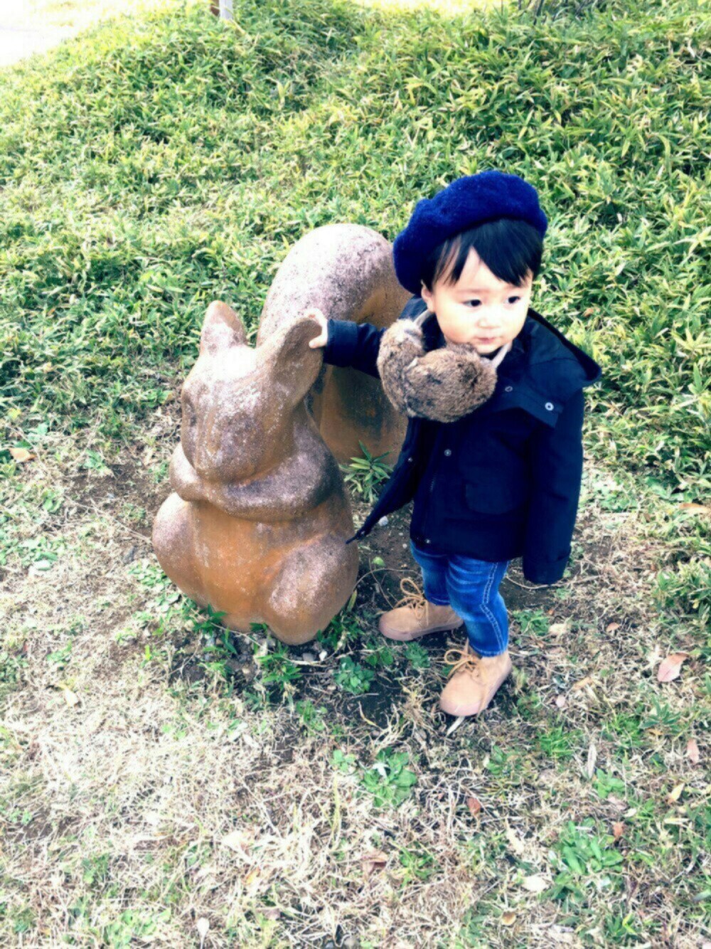 ブラック系のマウンテンパーカー、ブルー系のデニムパンツ、ベージュ系のブーツを着用したキッズの秋コーディネートの1枚目の写真