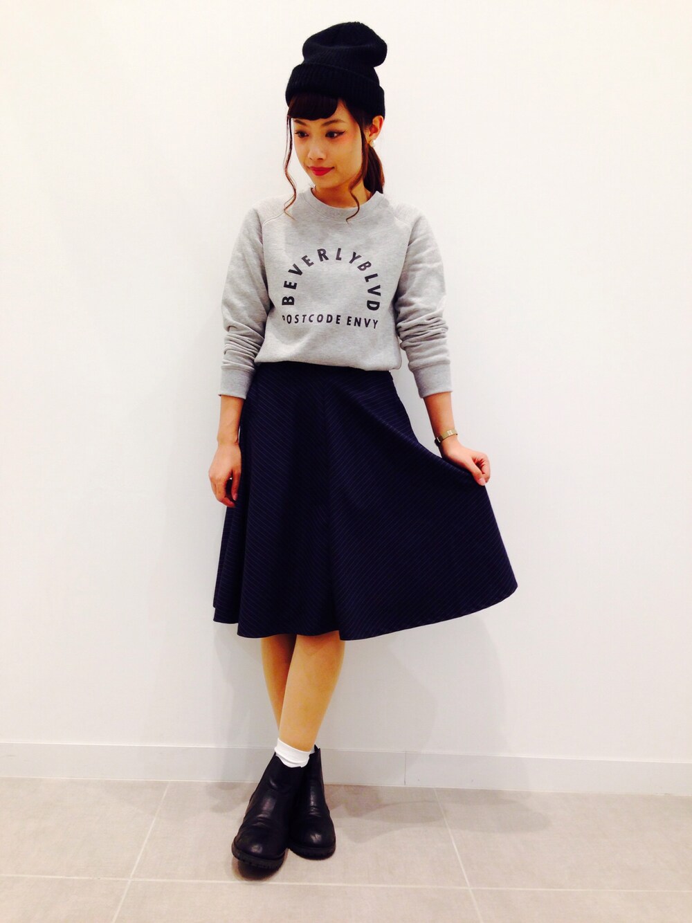 グレー系のスウェット、ブルー系のスカートを着用したレディースの冬コーディネートの1枚目の写真