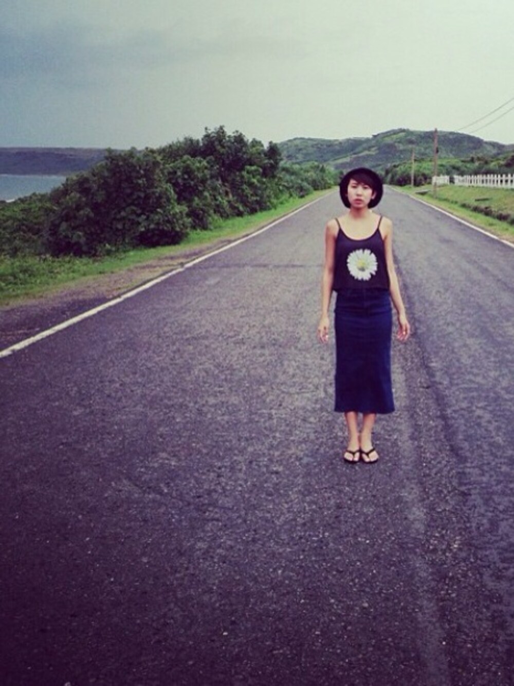 ブラック系のキャミソール、ブルー系のデニムスカートを着用したレディースの夏コーディネートの1枚目の写真