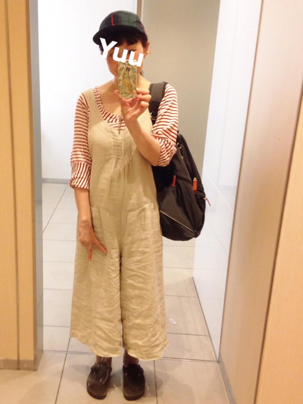 ブラウン系のサンダル、ベージュ系のサロペット/オーバーオール、ブラック系のバックパック/リュックを着用したレディースの秋コーディネートの1枚目の写真