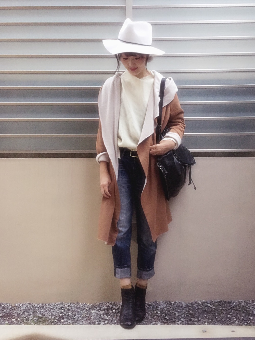 ホワイト系のニット/セーター、ベージュ系のカーディガン/ボレロ、ブラック系のバックパック/リュックを着用したレディースの秋コーディネートの1枚目の写真