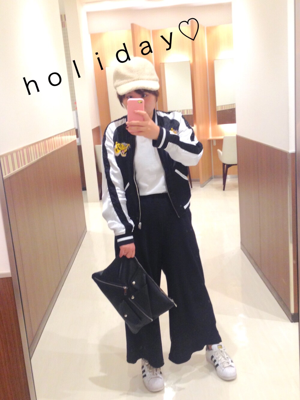 ホワイト系のスニーカー、ブラック系のクラッチバッグ、ブラック系のその他パンツを着用したレディースの秋コーディネートの1枚目の写真