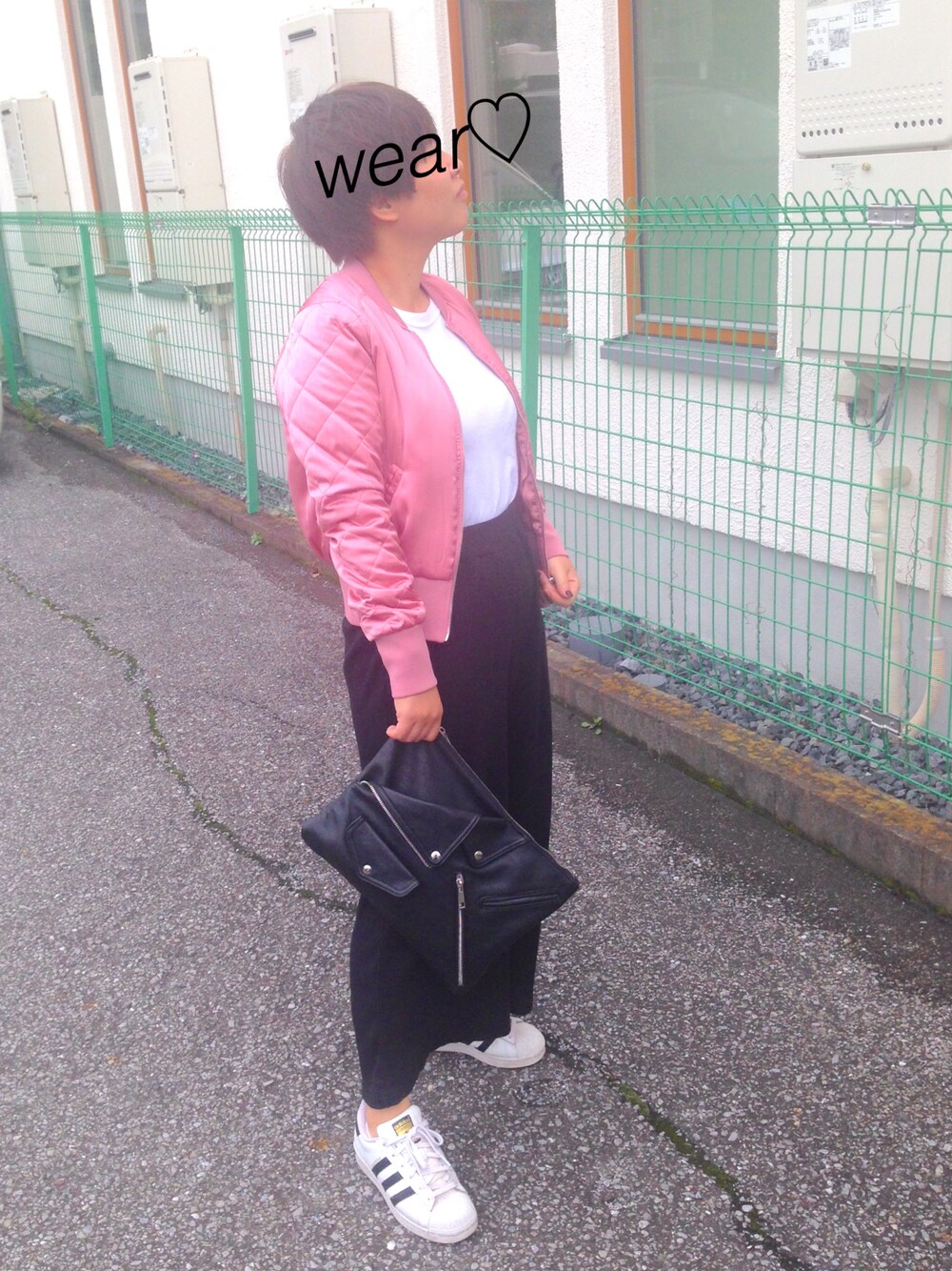 ホワイト系のスニーカー、ブラック系のクラッチバッグ、ブラック系のその他パンツを着用したレディースの秋コーディネートの1枚目の写真