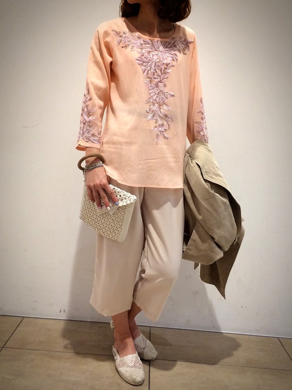 ピンク系のシャツ/ブラウス、ベージュ系のトレンチコート、ホワイト系のその他シューズを着用したレディースの冬コーディネートの1枚目の写真