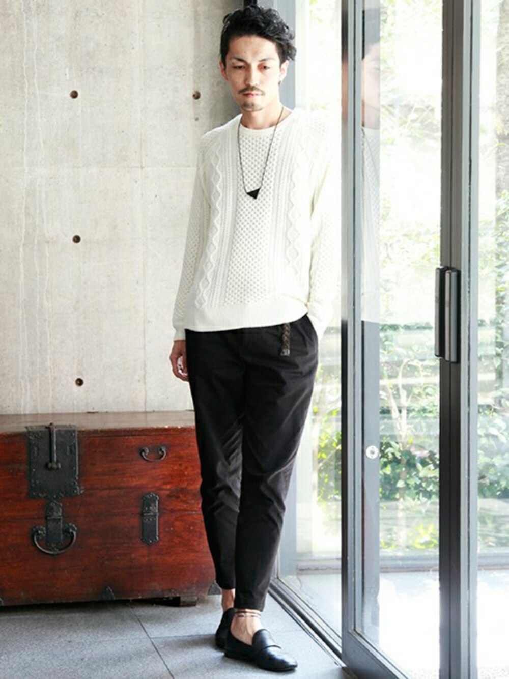 ホワイト系のニット/セーター、ブラック系のチノパンツを着用したメンズの秋コーディネートの1枚目の写真