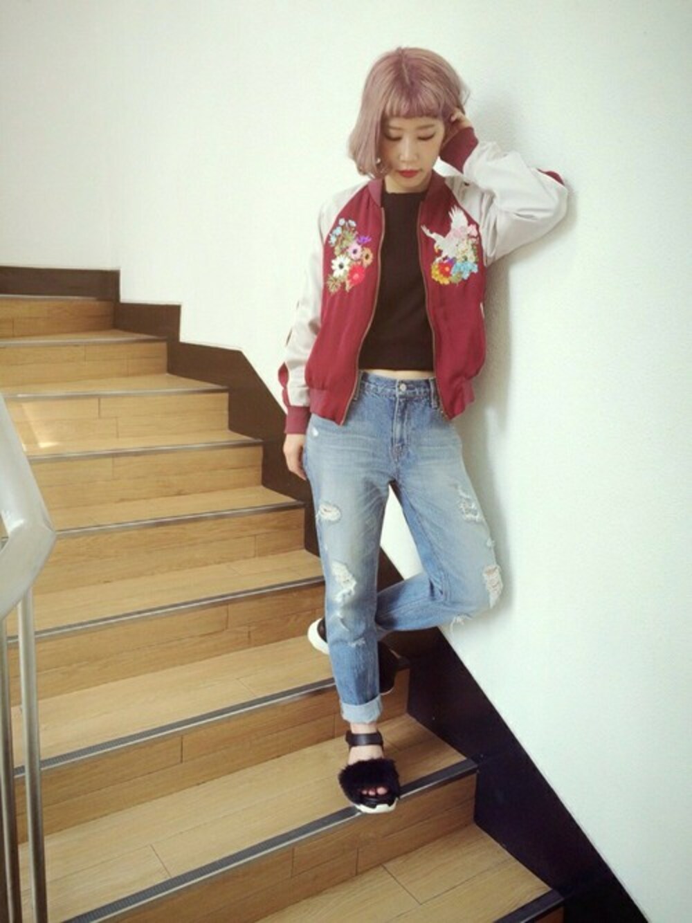 ブラック系のニット/セーター、レッド系のナイロンジャケット、ブルー系のデニムパンツを着用したレディースの秋コーディネートの1枚目の写真