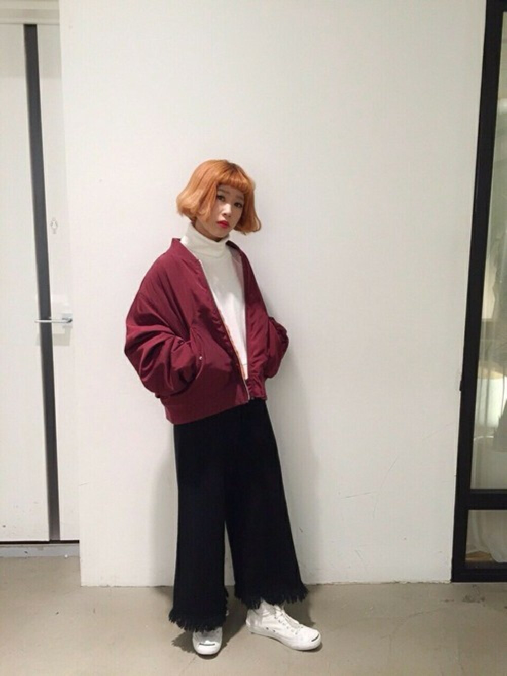 レッド系のMA-1、ホワイト系のスウェット、ブラック系のその他パンツを着用したレディースの冬コーディネートの1枚目の写真