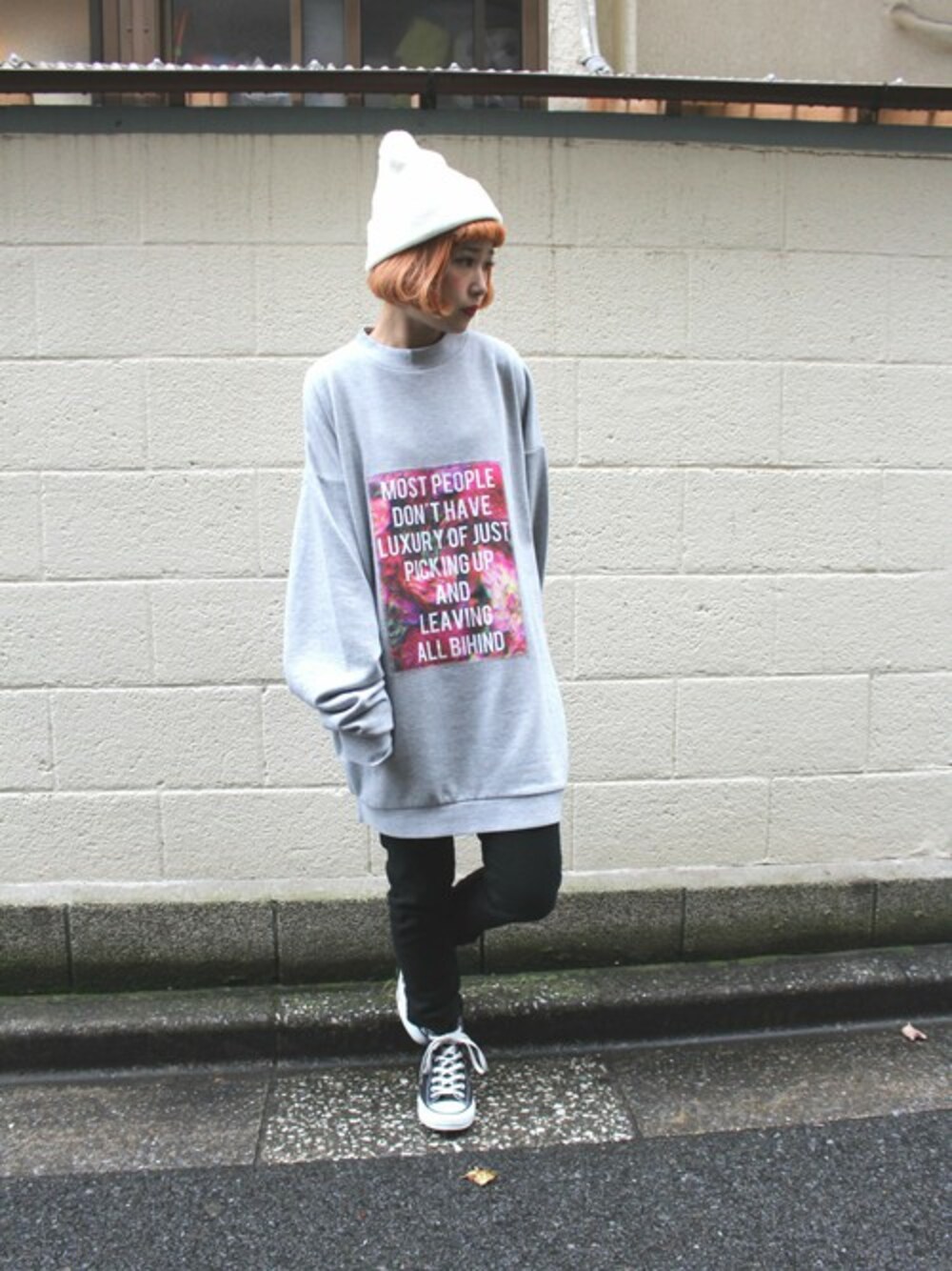 グレー系のスウェット、ブラック系のデニムパンツ、ホワイト系のニットキャップ/ビーニーを着用したレディースの冬コーディネートの1枚目の写真