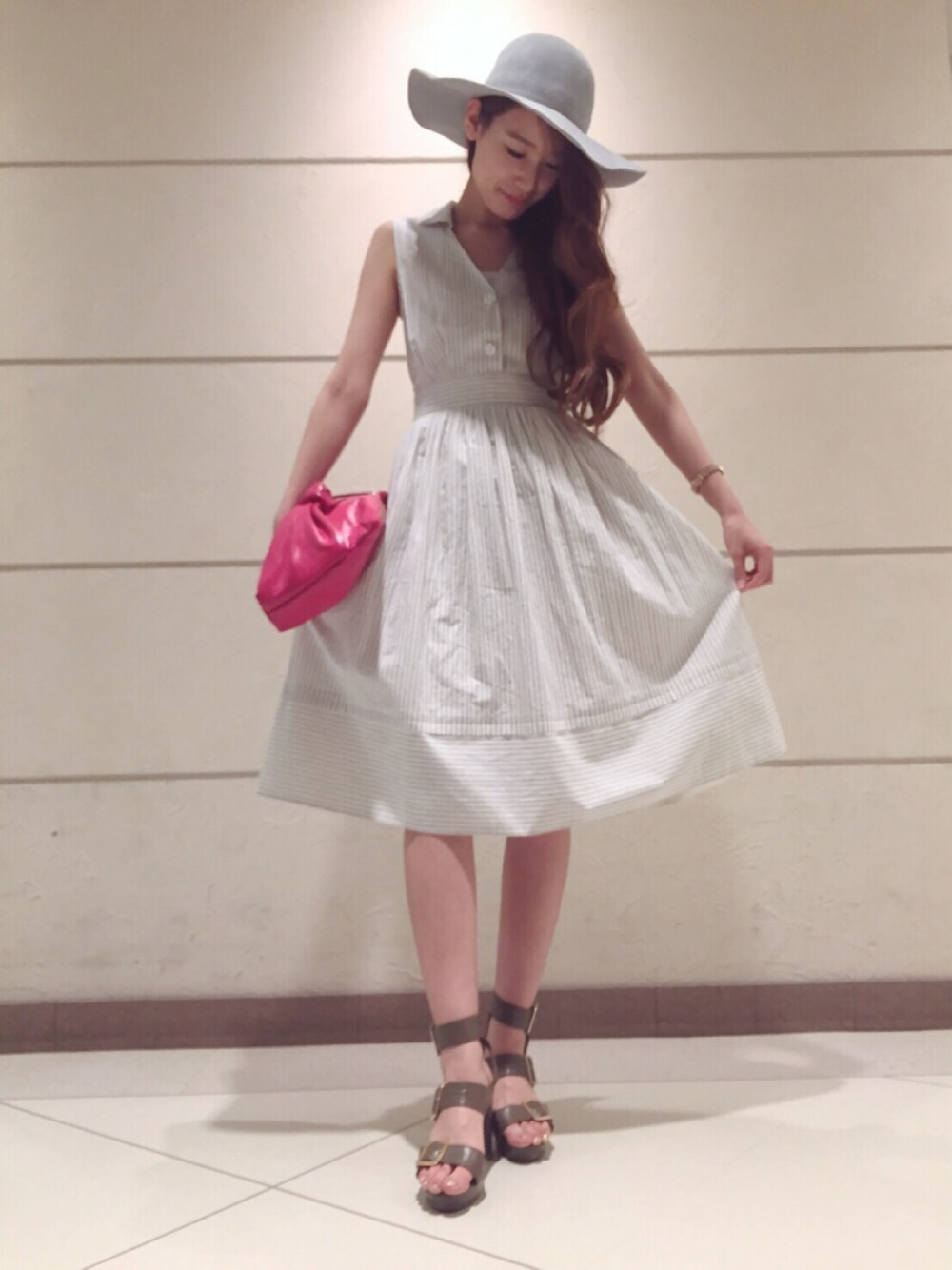 ホワイト系のワンピース、レッド系のクラッチバッグ、グリーン系のサンダルを着用したレディースの春コーディネートの1枚目の写真