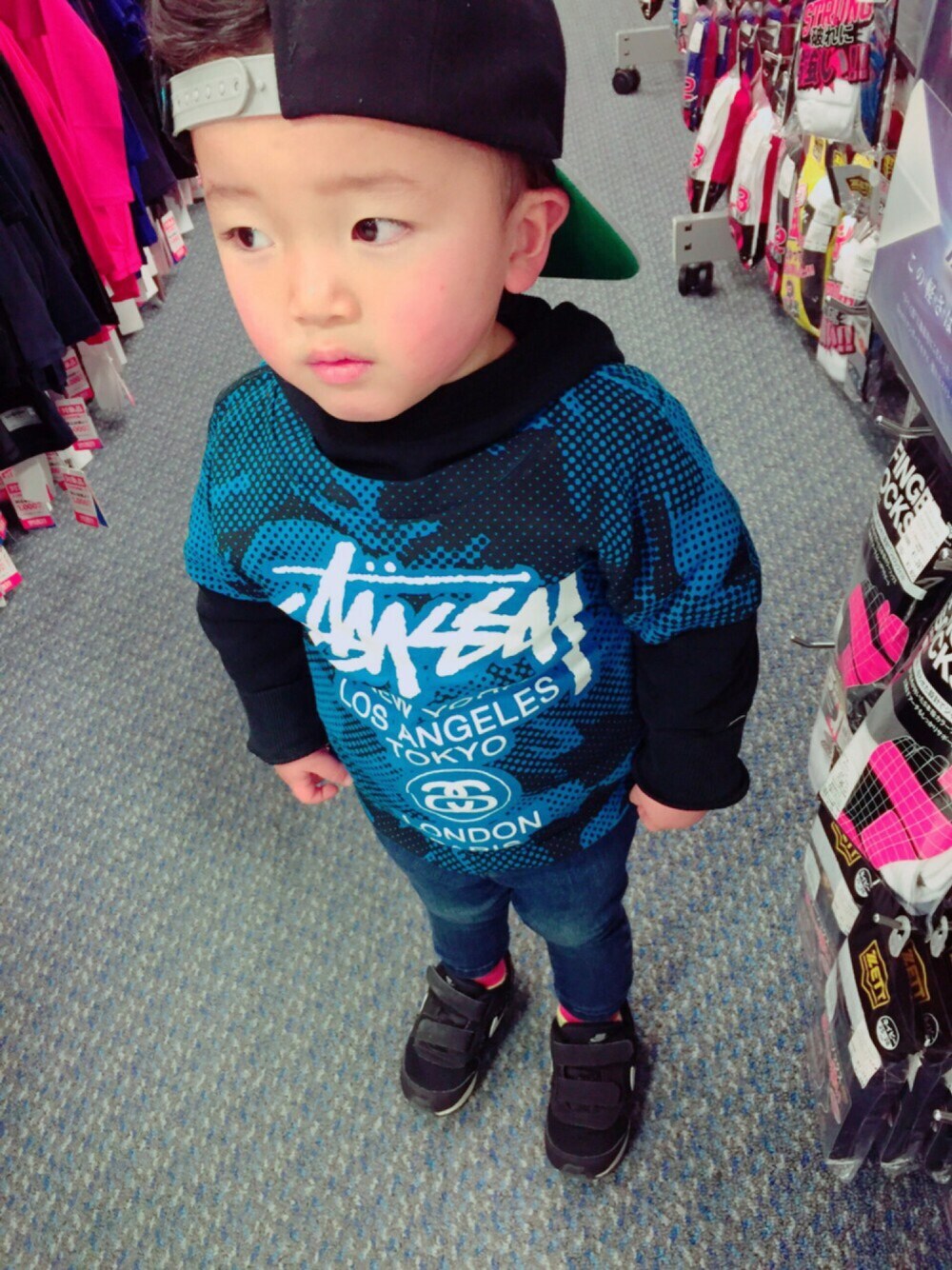 ブルー系のTシャツ/カットソー、ブラック系のスニーカー、ブラック系のキャップを着用したキッズの冬コーディネートの1枚目の写真