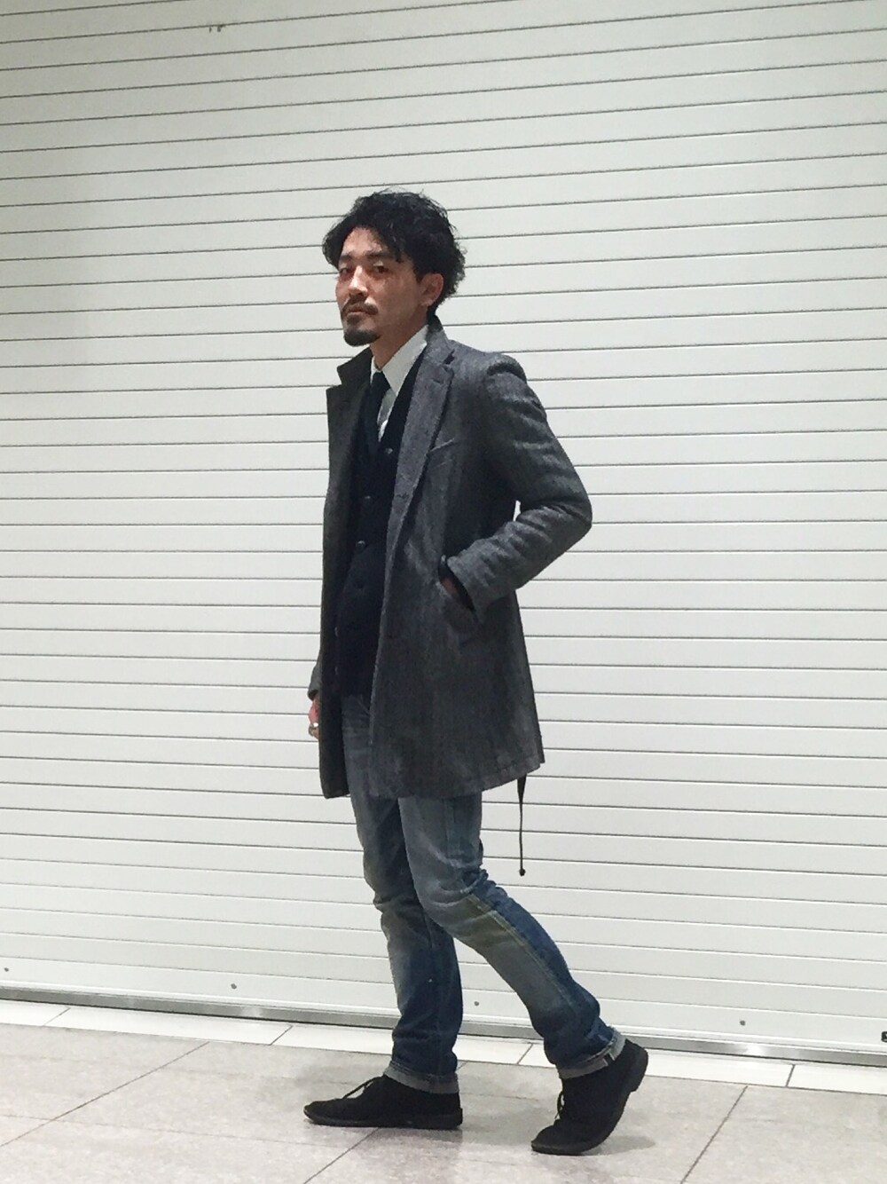 ホワイト系のシャツ/ブラウス、ブラック系のカーディガン/ボレロ、グレー系のチェスターコートを着用したメンズの冬コーディネートの1枚目の写真