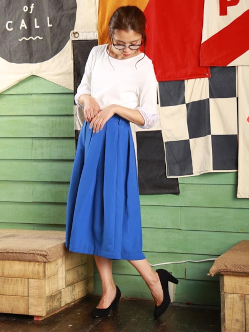 ブルー系のスカート、ホワイト系のTシャツ/カットソー、イエロー系のピアス（両耳用）を着用したレディースの春コーディネートの1枚目の写真