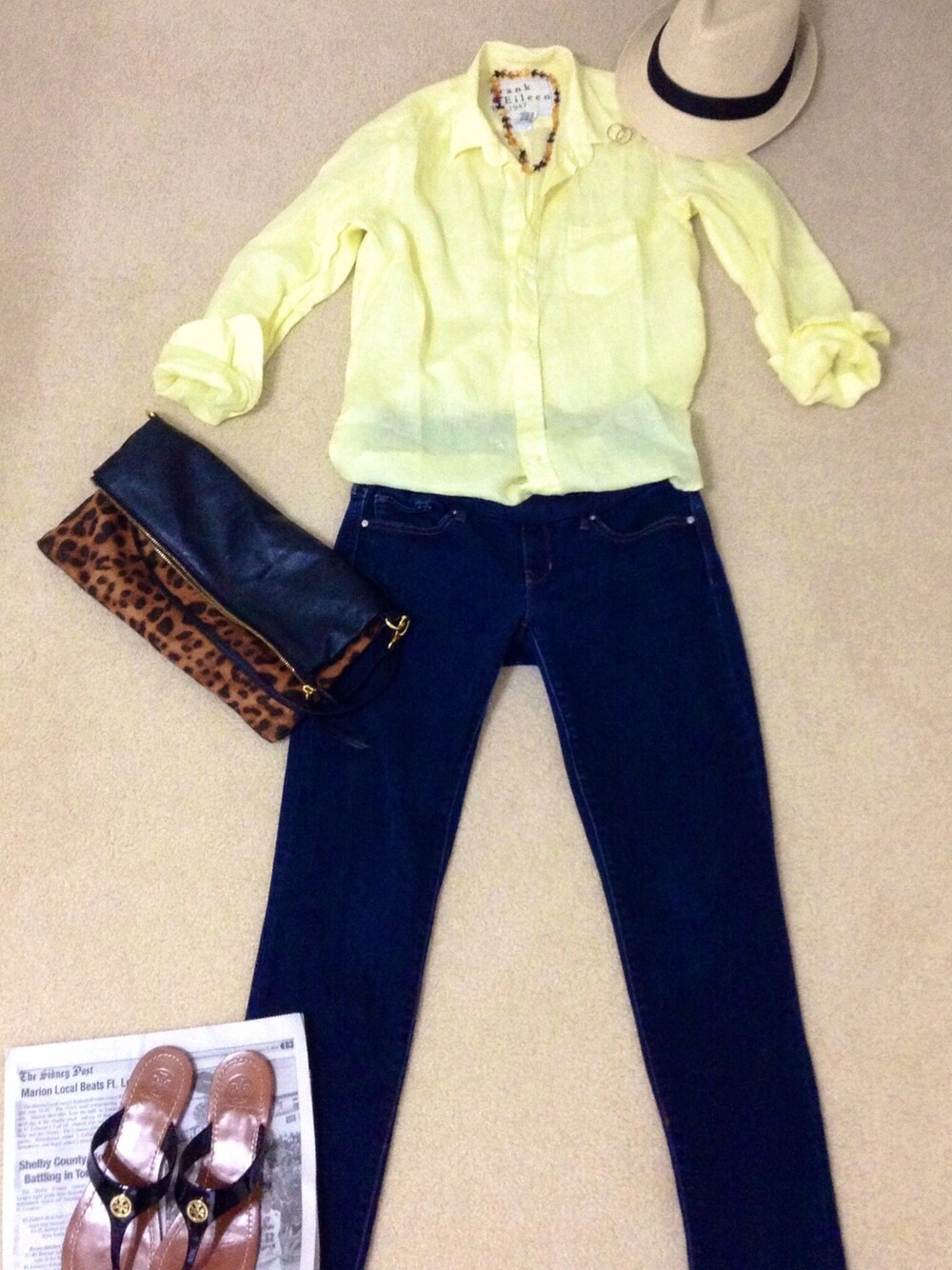 ブラウン系のクラッチバッグ、ブラウン系のネックレス、ゴールド系のピアス(両耳用)を着用したレディースの春コーディネートの1枚目の写真