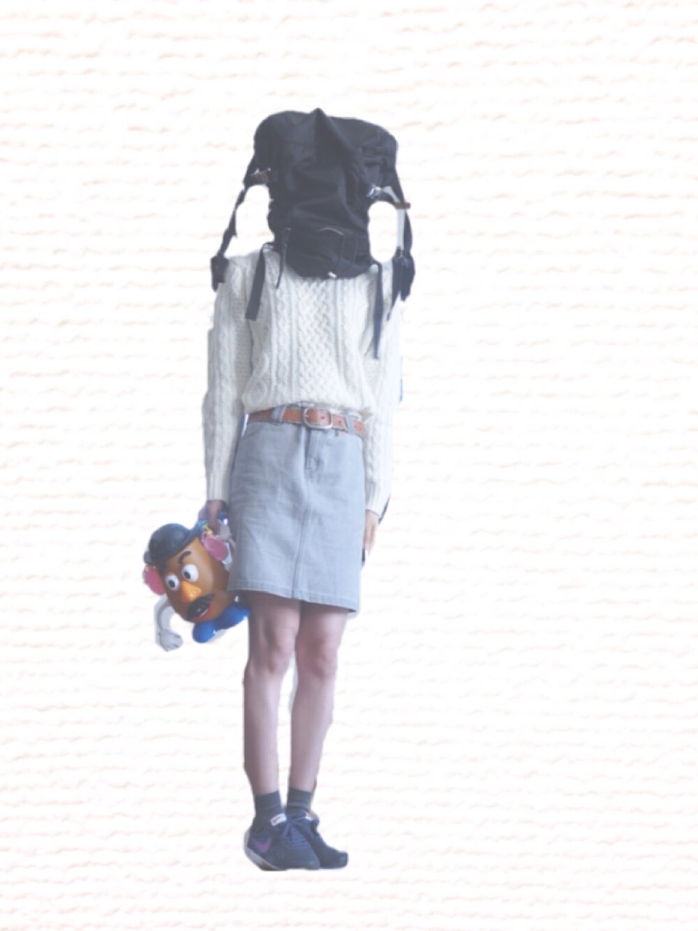 ブラック系のバックパック/リュック、ホワイト系のニット/セーター、グレー系のデニムスカートを着用したレディースの秋コーディネートの1枚目の写真