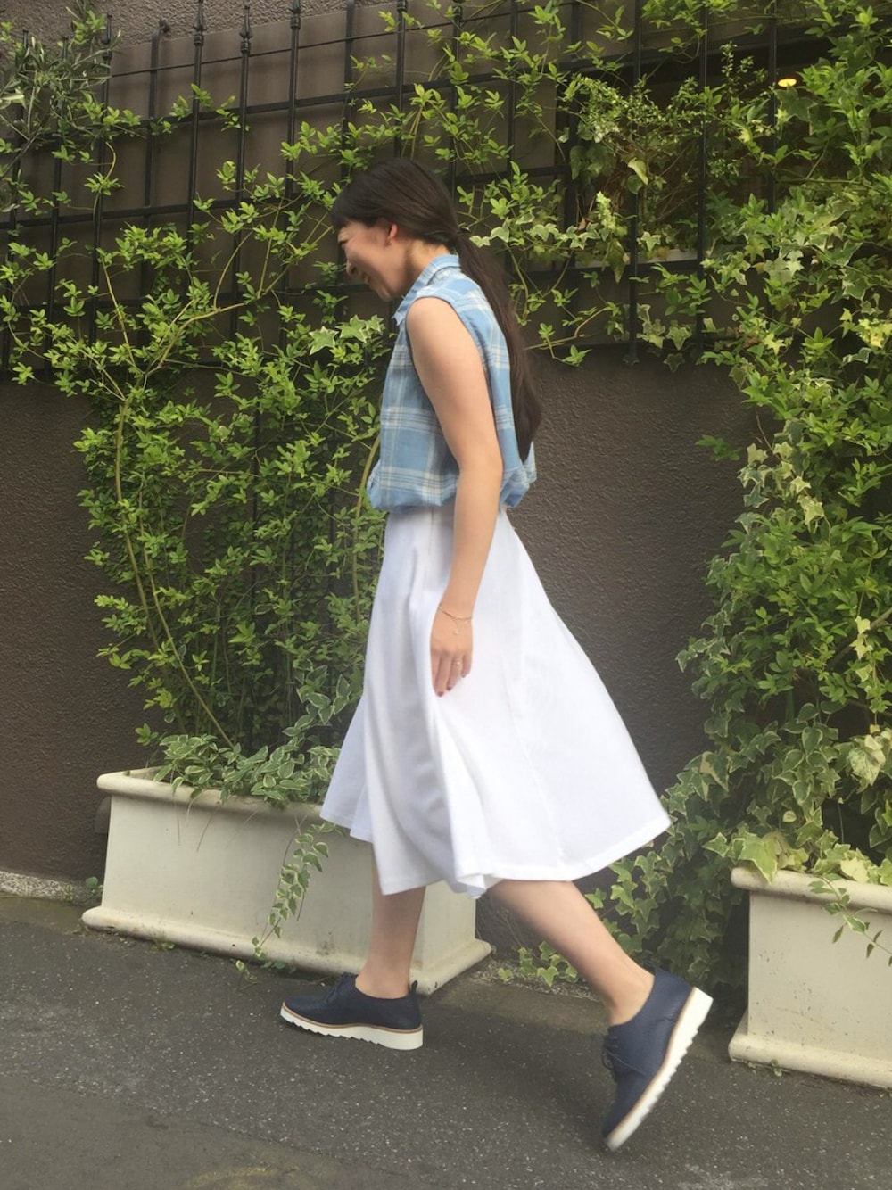 ブルー系のシャツ/ブラウス、ホワイト系のスカート、ブルー系のスニーカーを着用したレディースの夏コーディネートの1枚目の写真