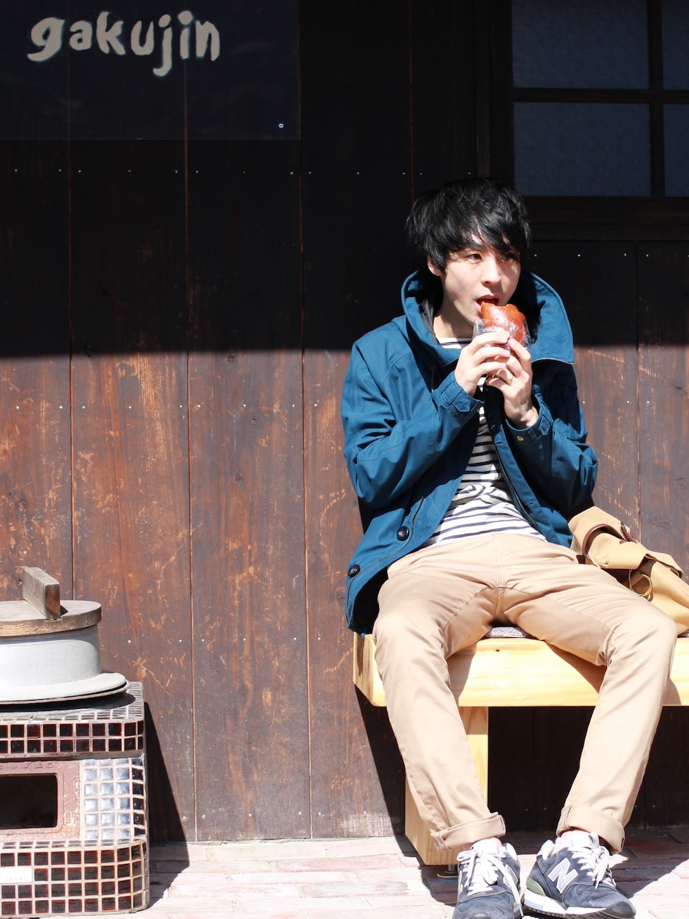 ブルー系のマウンテンパーカー、ブルー系のTシャツ/カットソー、グリーン系のチノパンツを着用したメンズの冬コーディネートの1枚目の写真