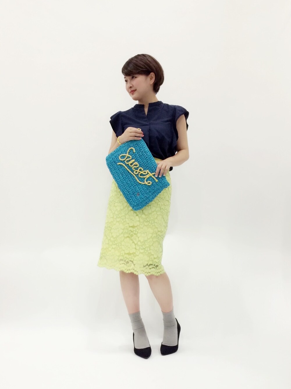 ブルー系のクラッチバッグ、イエロー系のスカート、ブルー系のシャツ/ブラウスを着用したレディースの春コーディネートの1枚目の写真