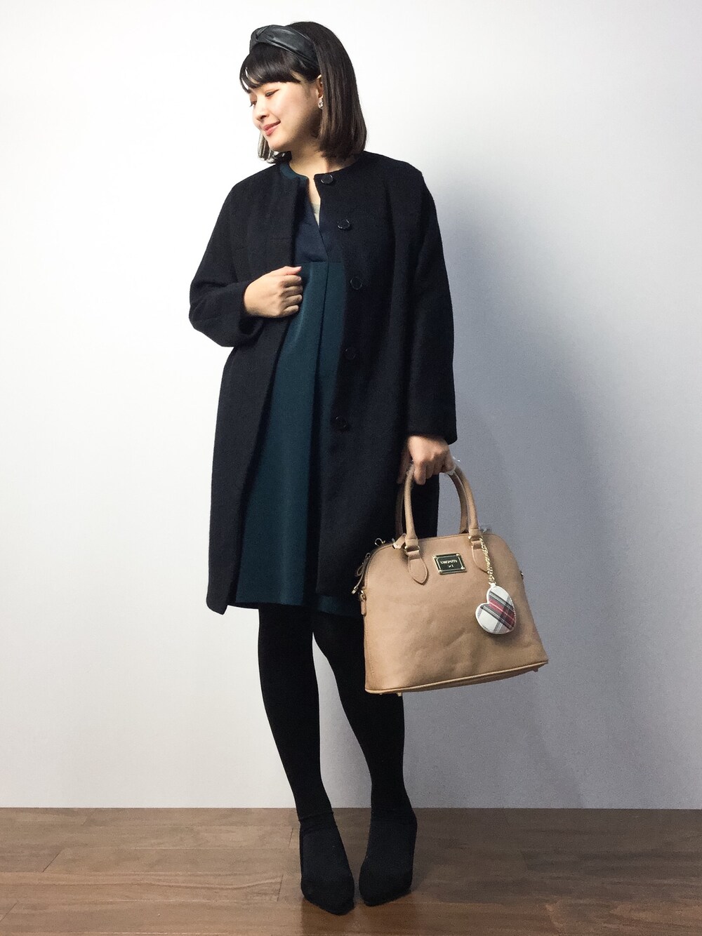 グリーン系のワンピース、ブラック系のその他アウター、ベージュ系のボストンバッグを着用したレディースの秋コーディネートの1枚目の写真