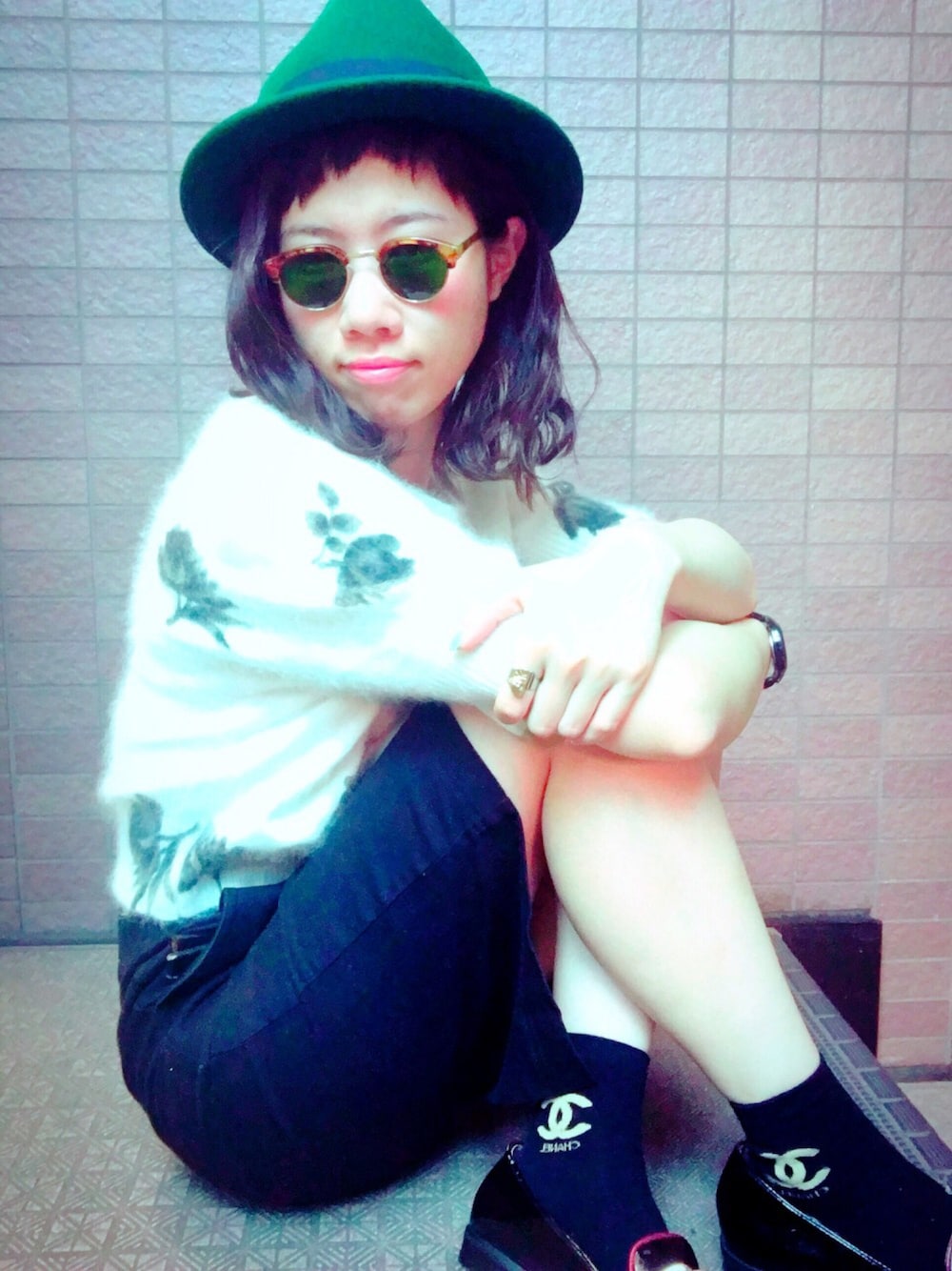 ホワイト系のトップス、ブラック系のスカート、グリーン系のハットを着用したレディースの夏コーディネートの1枚目の写真