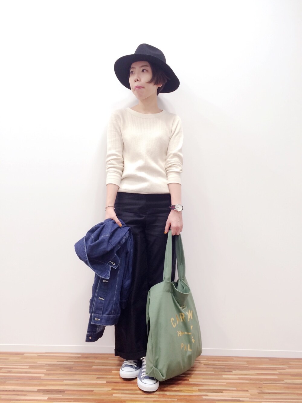 グリーン系のトートバッグを着用したレディースの秋コーディネートの1枚目の写真