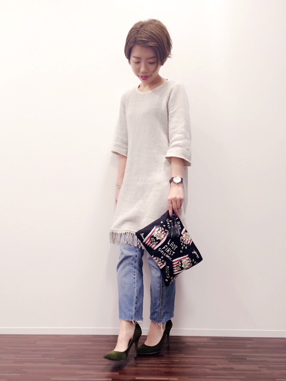 ブラック系のクラッチバッグ、ホワイト系のワンピース、グリーン系のパンプスを着用したレディースの秋コーディネートの1枚目の写真