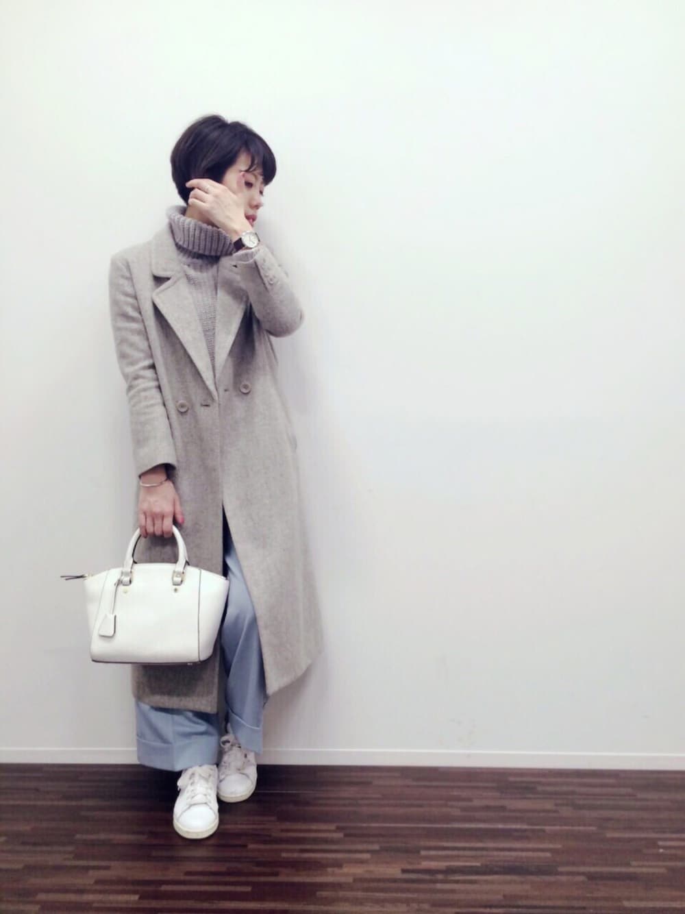 ホワイト系のボストンバッグ、グレー系のその他アウター、ゴールド系のリングを着用したレディースの冬コーディネートの1枚目の写真