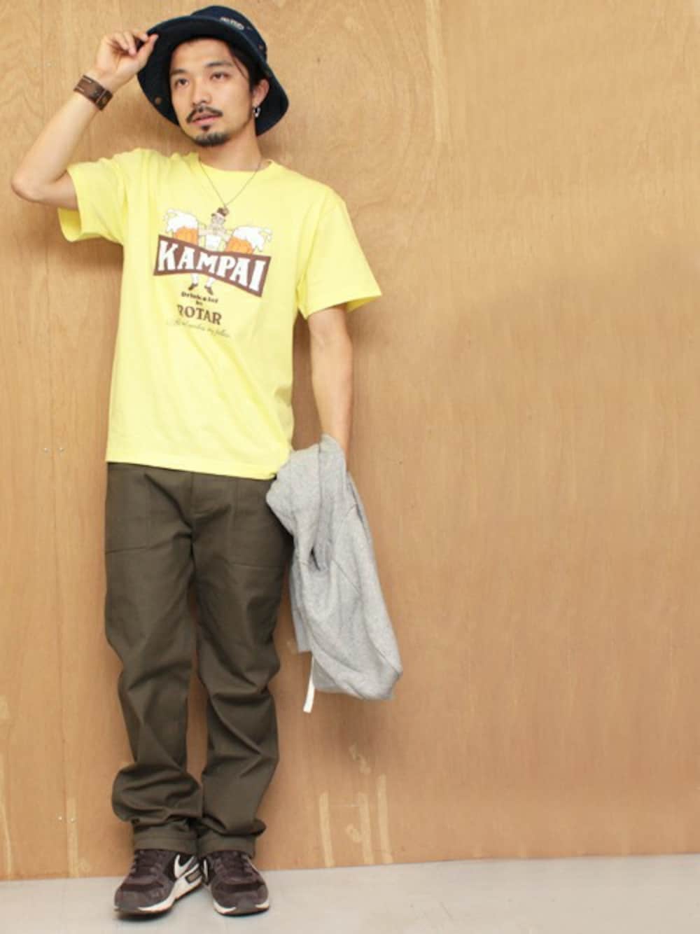 「イエロー、カーキのカーゴパンツ、ワークパンツ、ファティーグパンツ、ビール、イエローコーデ、サファリハット」｜「ROTARのKAMPAI my fellas s/s Tee（Tシャツ/カットソー、イエロー系）」を使った、Yusukeさん（メンズ・170cm）の春コーディネートの1枚目の写真