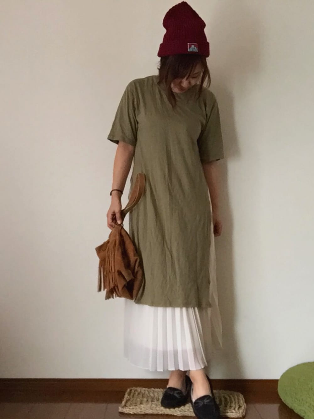 グリーン系のTシャツ/カットソー、ホワイト系のスカート、ブラック系のモカシン/デッキシューズを着用したレディースの秋コーディネートの1枚目の写真