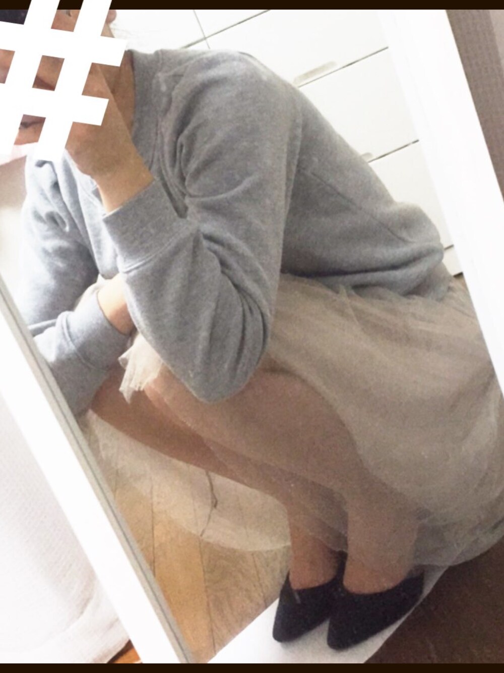 グレー系のパーカー、ブラック系のパンプス、ベージュ系のスカートを着用したレディースの秋コーディネートの1枚目の写真