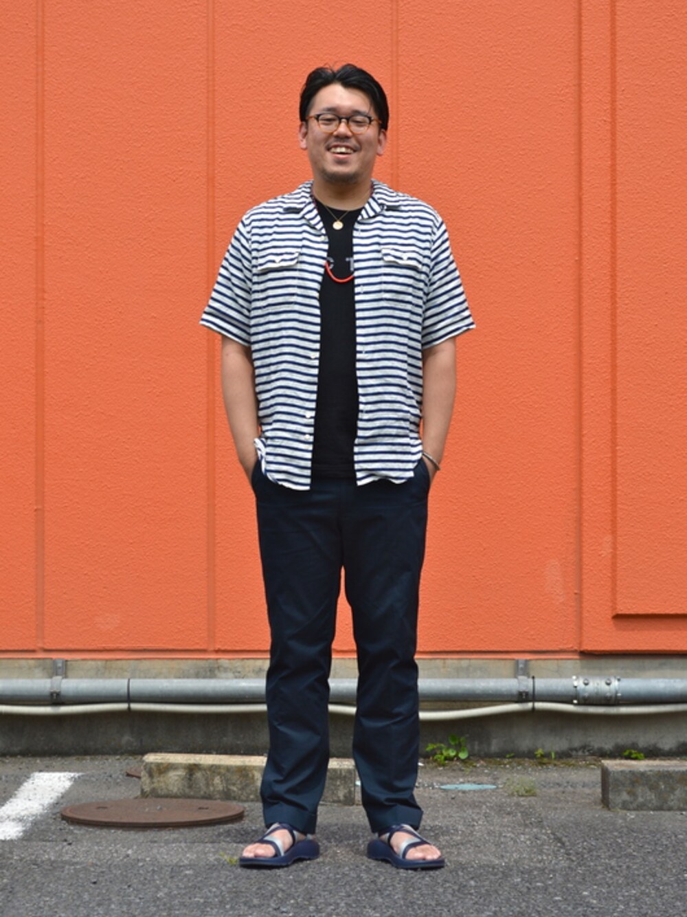 ブラック系のスラックスを着用したメンズの春コーディネートの1枚目の写真