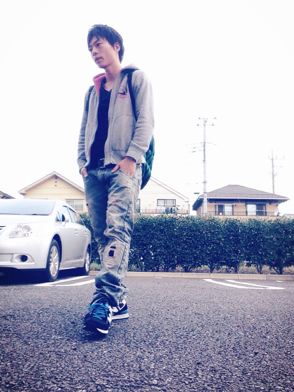 グレー系のパーカー、グリーン系のバックパック/リュック、ブラック系のスニーカーを着用したメンズの秋コーディネートの1枚目の写真