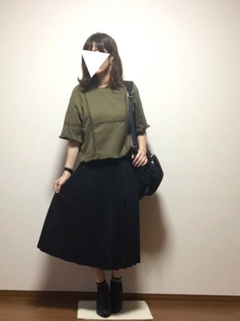グリーン系のTシャツ/カットソー、ブラック系のスカート、ブラック系のブーツを着用したレディースの秋コーディネートの1枚目の写真