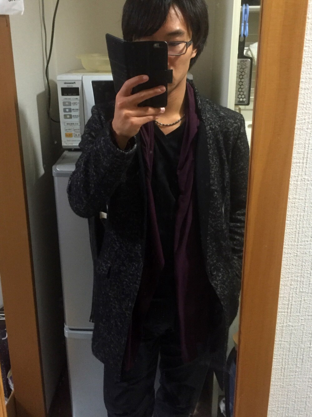 ブラック系のトレンチコート、レッド系のカーディガン/ボレロ、ブラック系のその他パンツを着用したメンズの冬コーディネートの1枚目の写真