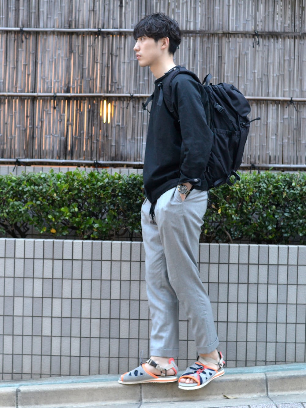 ブラック系のTシャツ/カットソー、グレー系のその他パンツ、グレー系のサンダルを着用したメンズの夏コーディネートの1枚目の写真