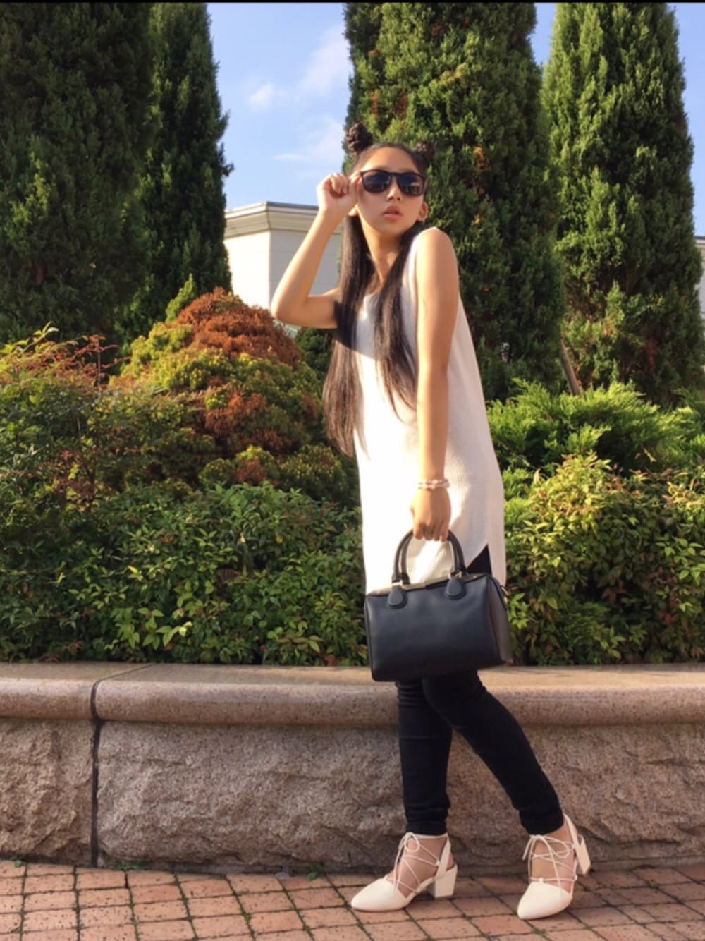 ホワイト系のニット/セーター、ブラック系のデニムパンツ、ブラック系のバッグを着用したレディースの秋コーディネートの1枚目の写真