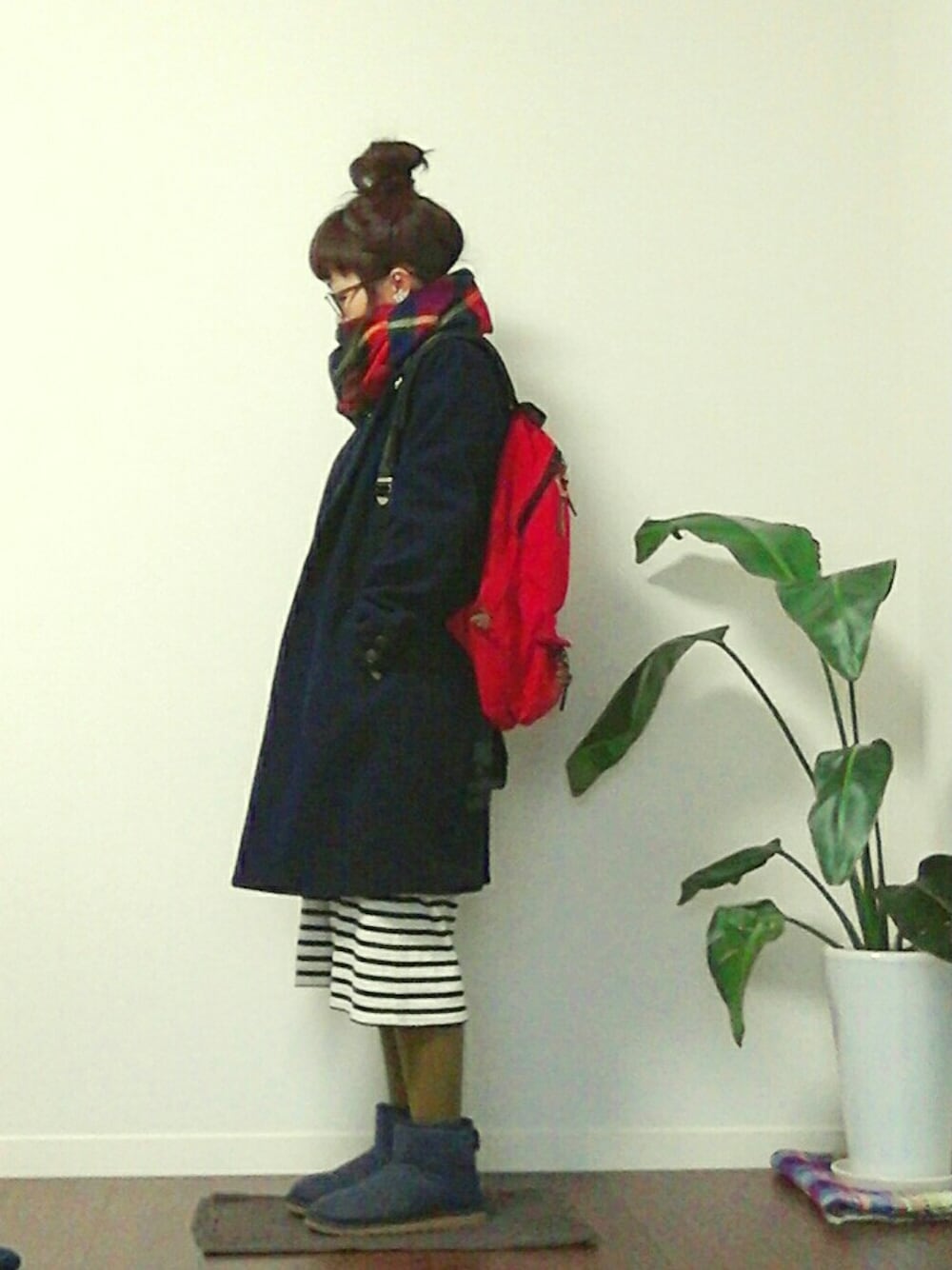 レッド系のバックパック/リュック、ブルー系のチェスターコート、ブルー系のブーツを着用したレディースの冬コーディネートの1枚目の写真