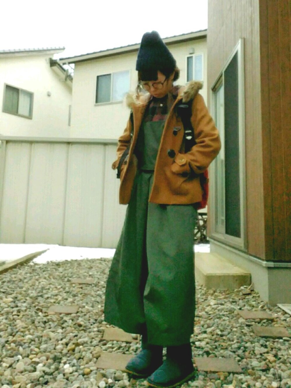 イエロー系のダッフルコート、ブルー系のブーツ、ブルー系のシャツ/ブラウスを着用したレディースの冬コーディネートの1枚目の写真