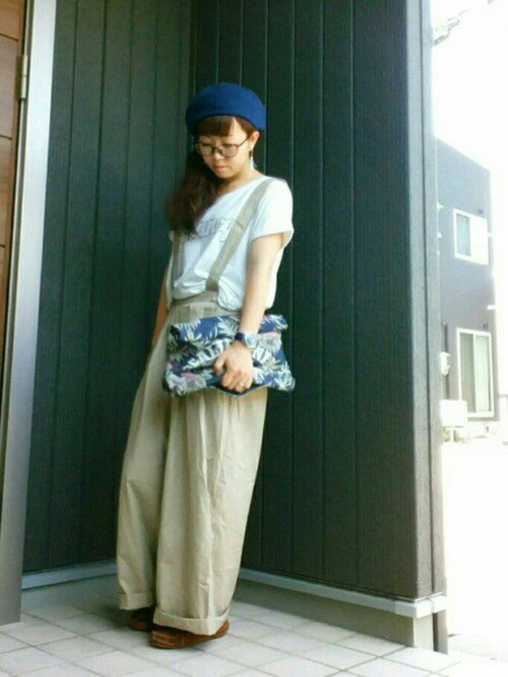 ブルー系のバッグ、ベージュ系のパンツ、ホワイト系のトップスを着用したレディースの夏コーディネートの1枚目の写真
