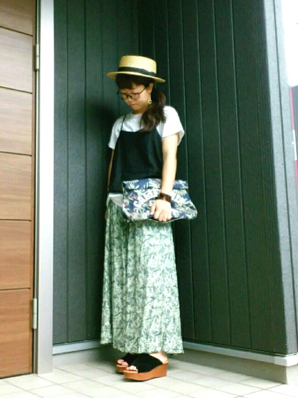 ブルー系のバッグ、ホワイト系のTシャツ/カットソー、ブラック系のサンダルを着用したレディースの夏コーディネートの1枚目の写真