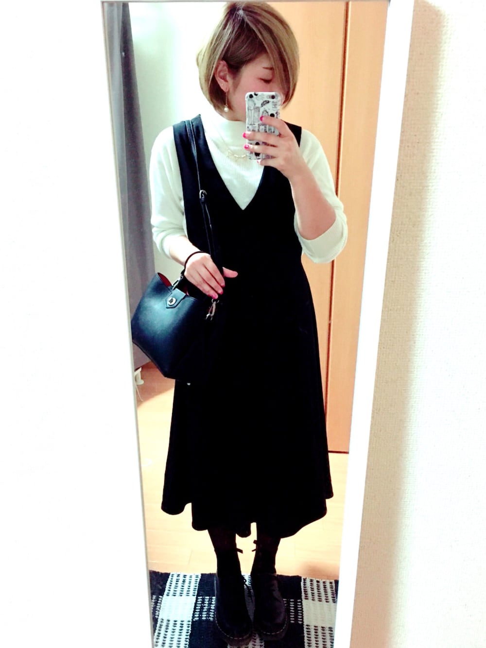 ホワイト系のニット/セーター、ブラック系のショルダーバッグ、ブラック系のブーツを着用したレディースの春コーディネートの1枚目の写真