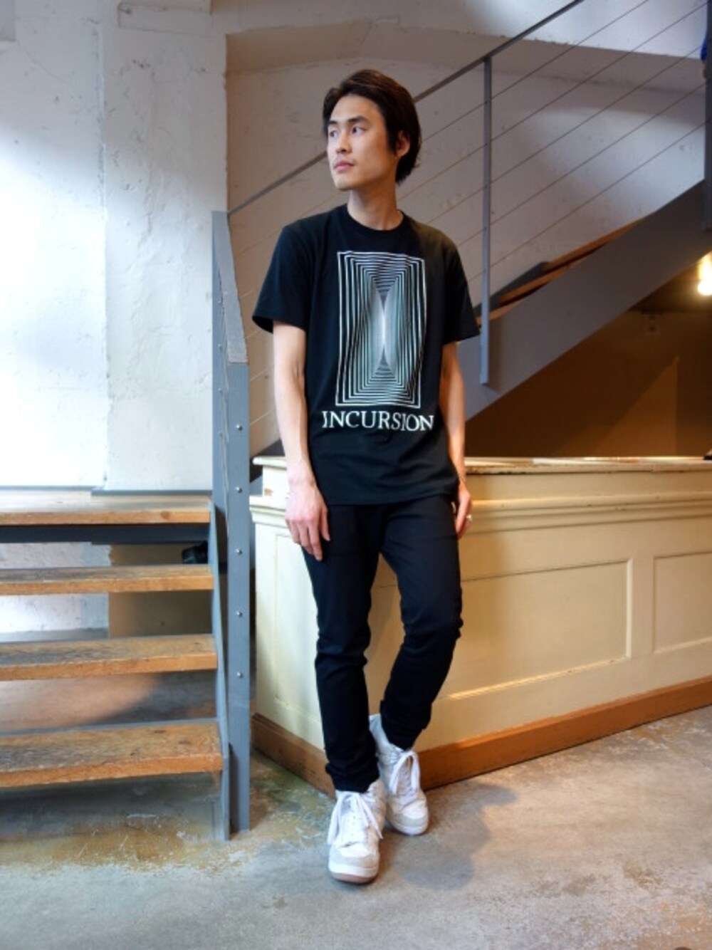 ブラック系のTシャツ/カットソー、ブラック系のその他パンツ、ホワイト系のスニーカーを着用したメンズの春コーディネートの1枚目の写真
