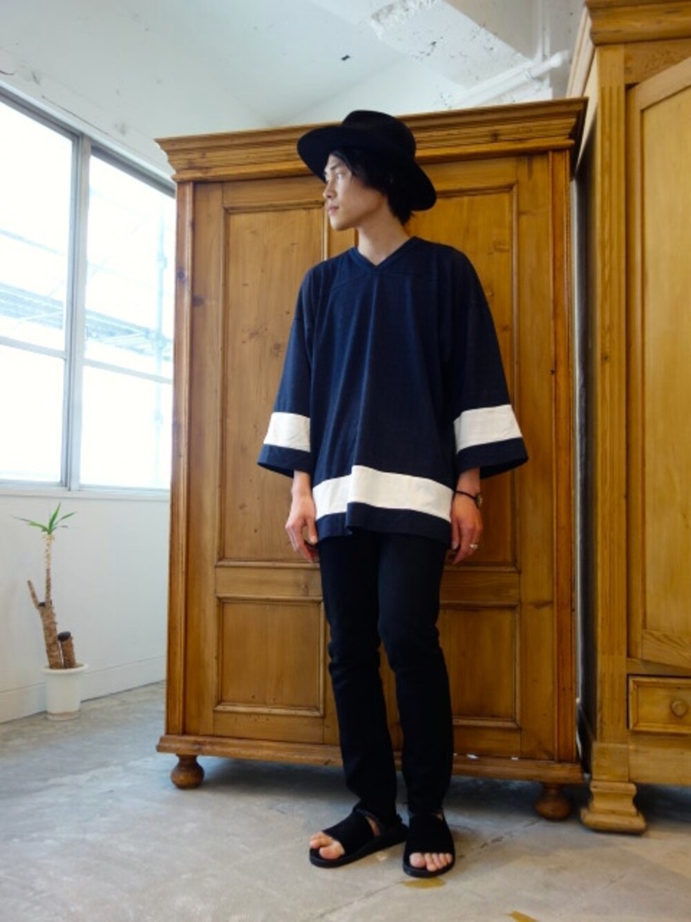 パープル系のTシャツ/カットソー、ブラック系のデニムパンツ、ブラック系のサンダルを着用したメンズの春コーディネートの1枚目の写真