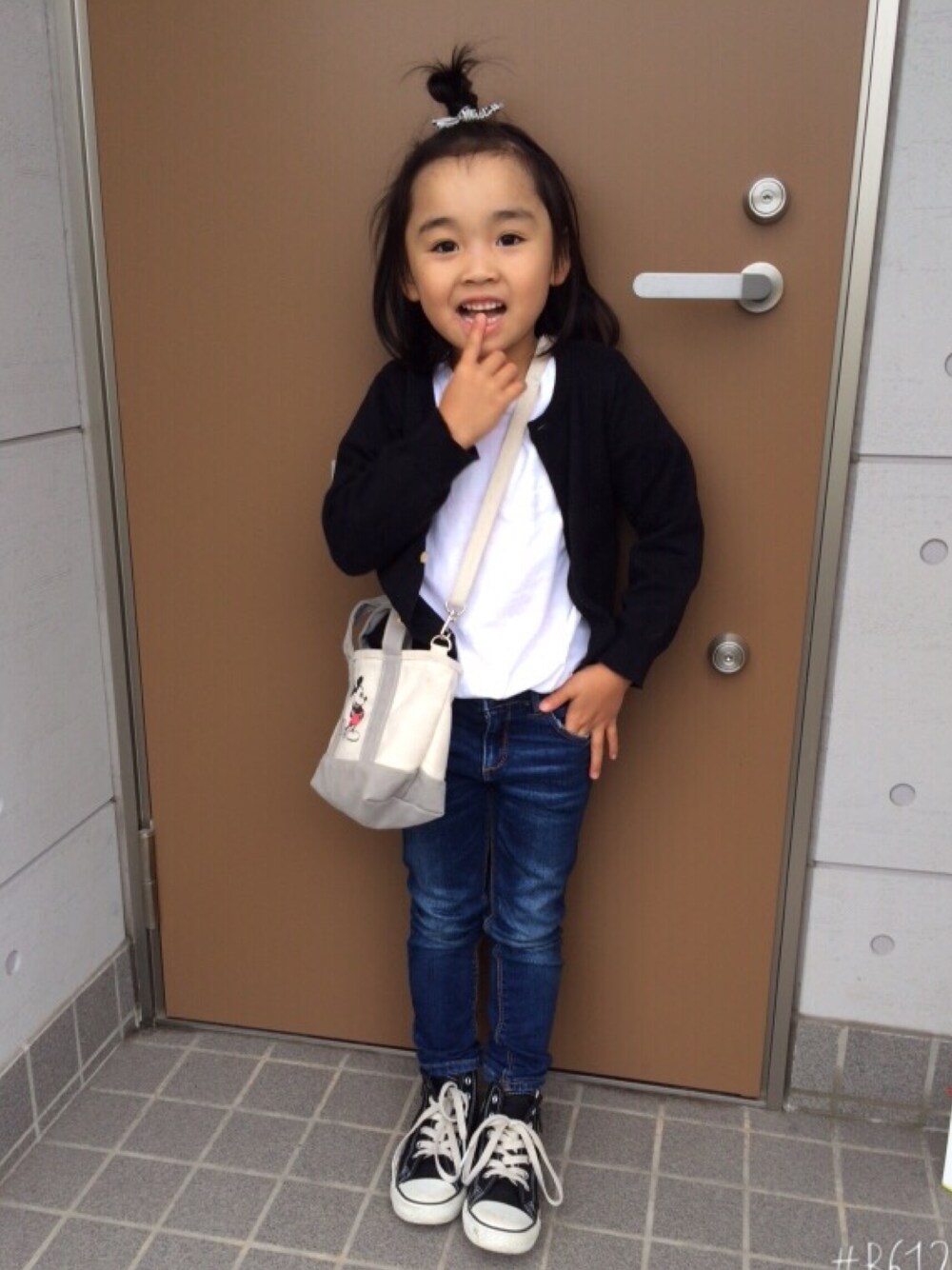 ブラック系のカーディガン/ボレロ、ホワイト系のTシャツ/カットソー、ブルー系のデニムパンツを着用したキッズの春コーディネートの1枚目の写真